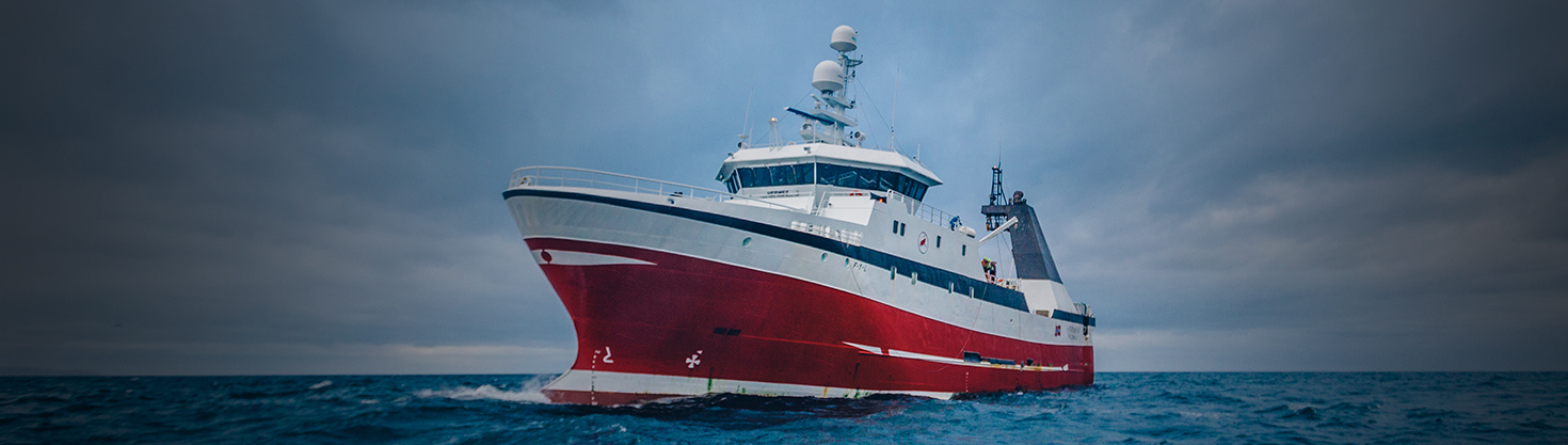 Close up of a fishing vessel sailing the sea on a sunny day.